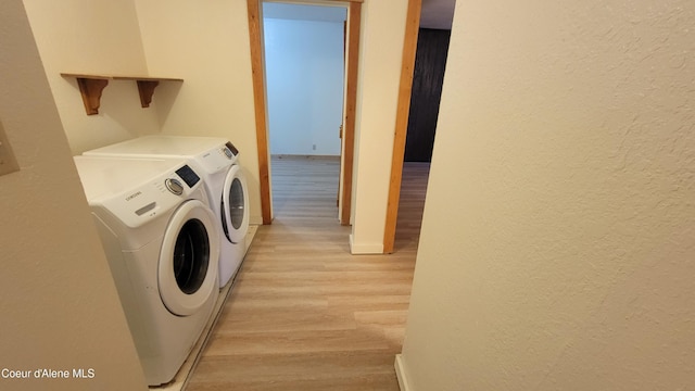 clothes washing area featuring light hardwood / wood-style floors and independent washer and dryer