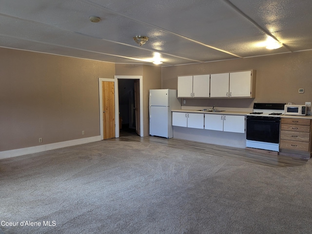 kitchen featuring a textured ceiling, white appliances, light colored carpet, sink, and white cabinetry