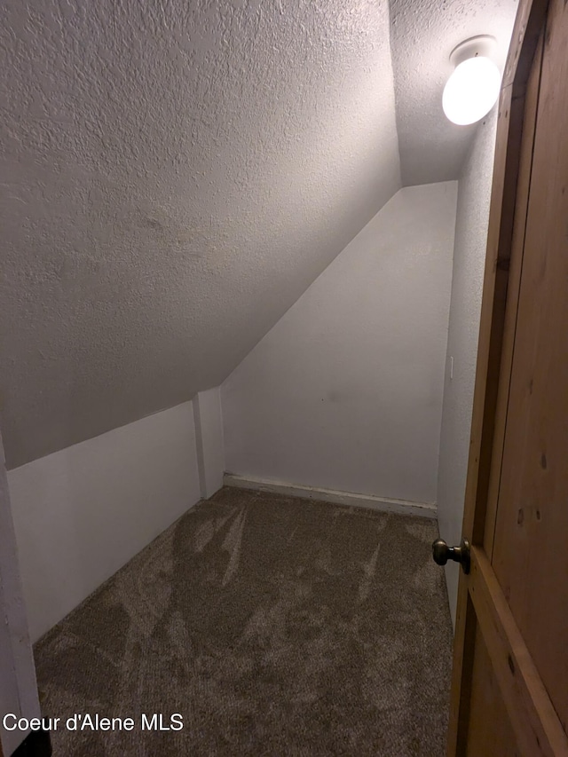 bonus room featuring carpet, a textured ceiling, and vaulted ceiling