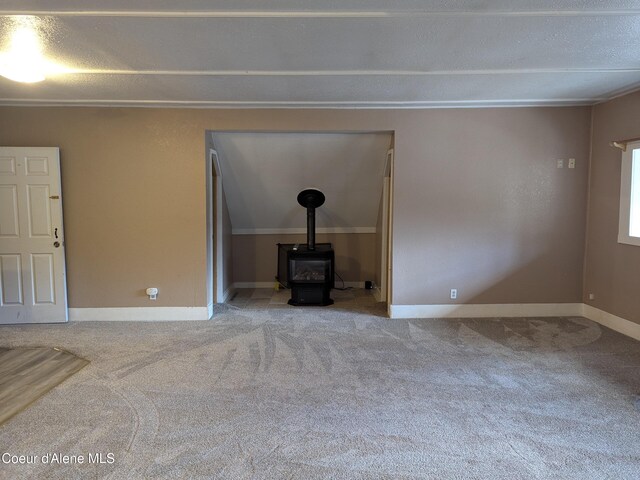 unfurnished living room with carpet and a wood stove