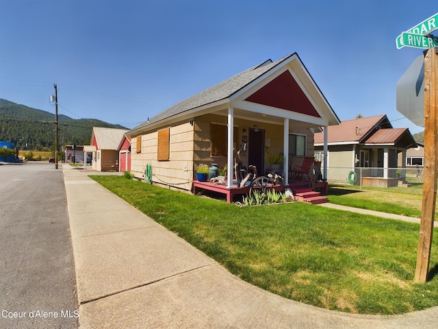 bungalow with a mountain view, covered porch, and a front yard