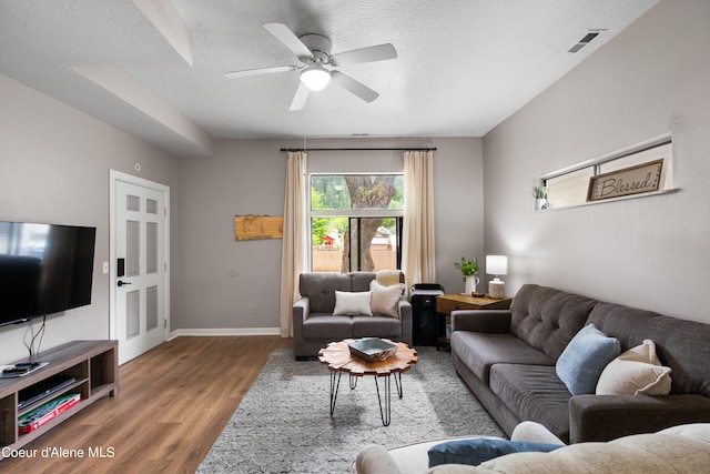 living room featuring ceiling fan, hardwood / wood-style floors, and a textured ceiling