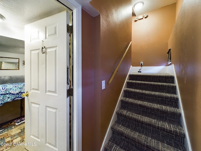 stairs featuring a textured ceiling