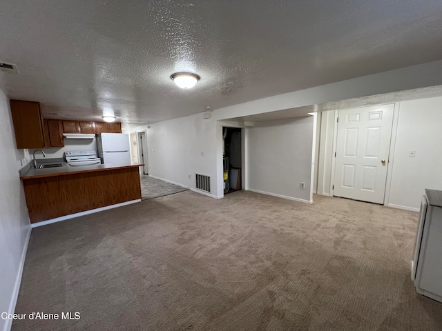 interior space featuring sink, white refrigerator, kitchen peninsula, a textured ceiling, and light carpet