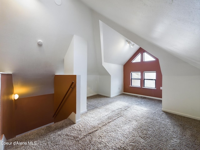 additional living space featuring carpet flooring and vaulted ceiling