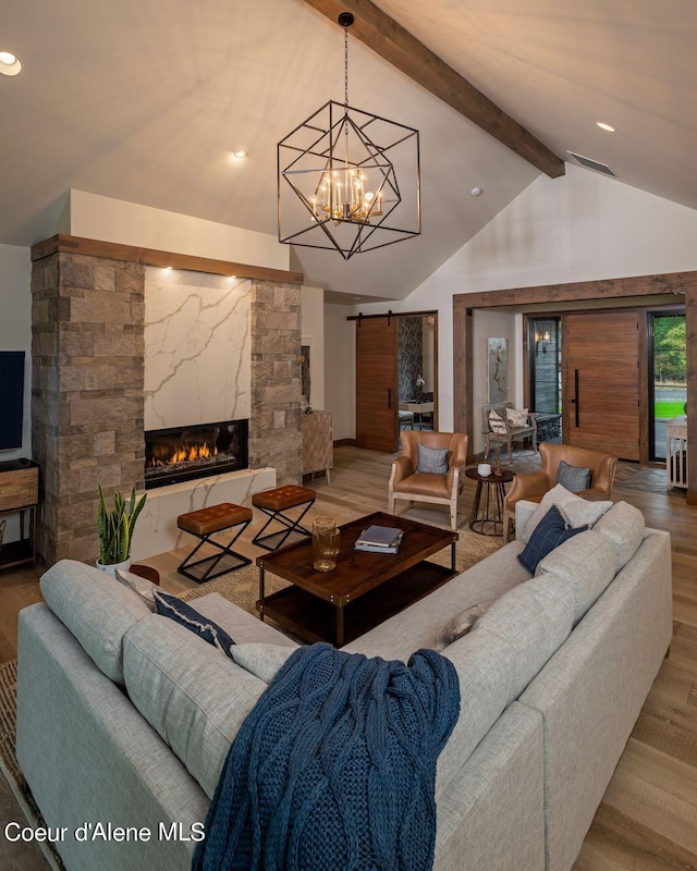 L3B10 N Walden Loop, Rathdrum, ID 83858 - living room featuring a notable chandelier, beam ceiling, a fireplace, a barn door, and hardwood / wood-style floors