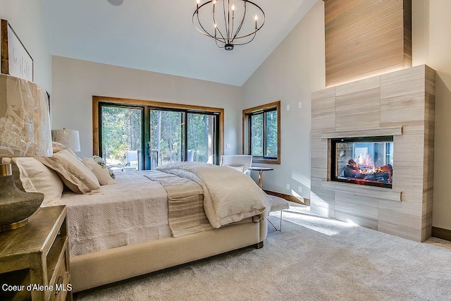 L3B10 N Walden Loop, Rathdrum, ID 83858 - carpeted bedroom featuring multiple windows, a tiled fireplace, a chandelier, and high vaulted ceiling
