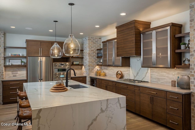 L3B10 N Walden Loop, Rathdrum, ID 83858 - kitchen featuring light hardwood / wood-style floors, sink, stainless steel appliances, backsplash, and a center island with sink