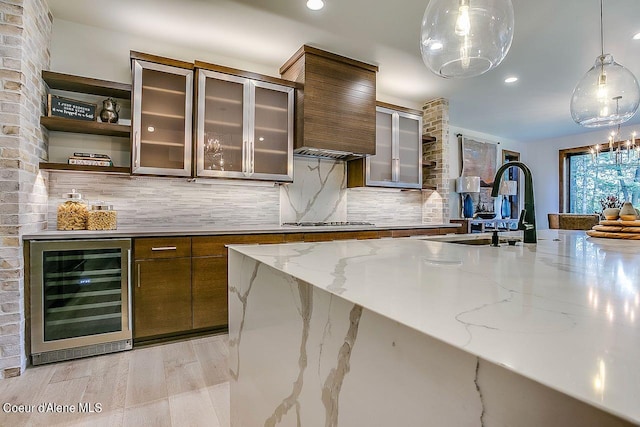L3B10 N Walden Loop, Rathdrum, ID 83858 - kitchen with hanging light fixtures, decorative backsplash, light stone counters, beverage cooler, and stainless steel gas stovetop