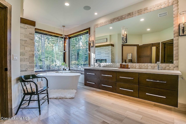 L3B10 N Walden Loop, Rathdrum, ID 83858 - bathroom featuring a bathtub, backsplash, a fireplace, vanity, and hardwood / wood-style flooring