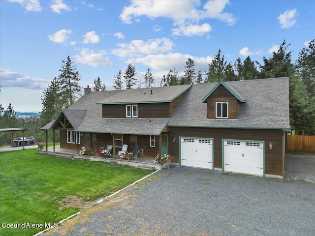 view of front of house with a garage, covered porch, and a front lawn