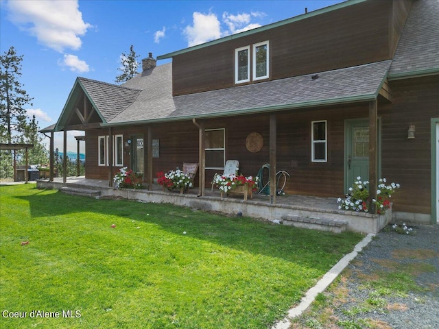 back of property with a porch and a lawn