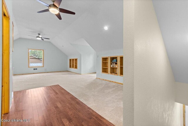 bonus room with light carpet, lofted ceiling, and ceiling fan