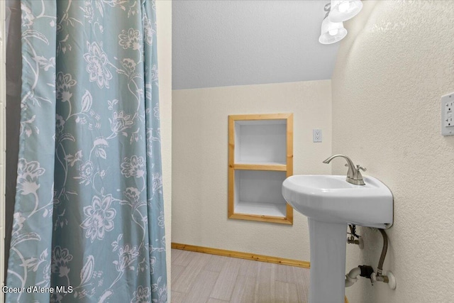 bathroom with a textured ceiling and hardwood / wood-style floors