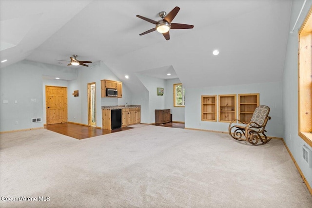 interior space featuring vaulted ceiling, ceiling fan, and carpet flooring