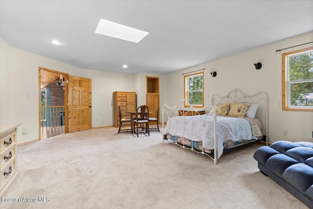 carpeted bedroom with a skylight and multiple windows