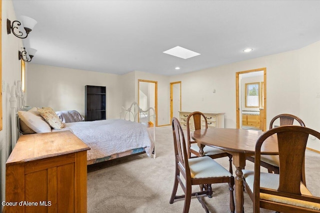 carpeted bedroom featuring a skylight and connected bathroom