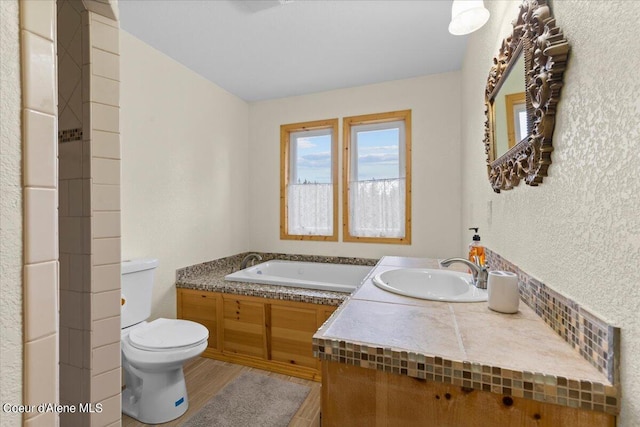 bathroom featuring vanity, toilet, hardwood / wood-style floors, and a bath