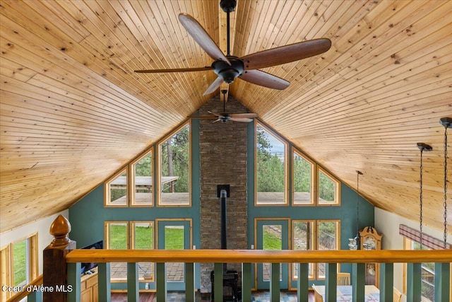 interior details featuring wood ceiling, a wood stove, and ceiling fan