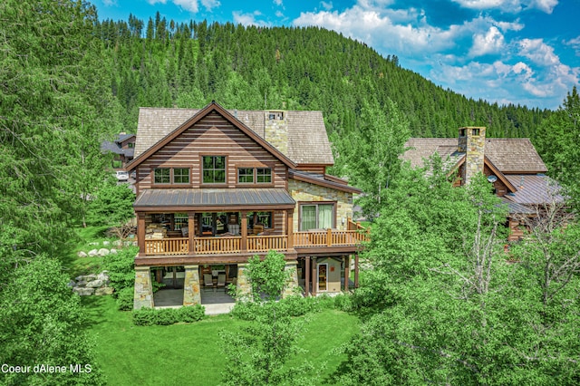 rear view of property with a yard, a patio, and a wooden deck