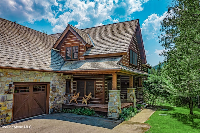 cabin with a porch and a garage