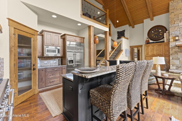 kitchen with wood ceiling, hardwood / wood-style flooring, high vaulted ceiling, and built in appliances