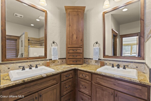 full bath with double vanity, visible vents, and a sink