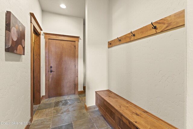 mudroom featuring stone finish flooring and baseboards