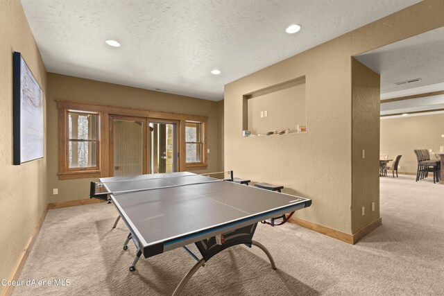 playroom with carpet floors, baseboards, and a textured ceiling