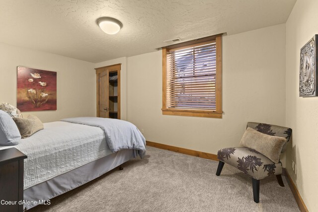 bedroom featuring carpet, baseboards, a textured ceiling, and visible vents