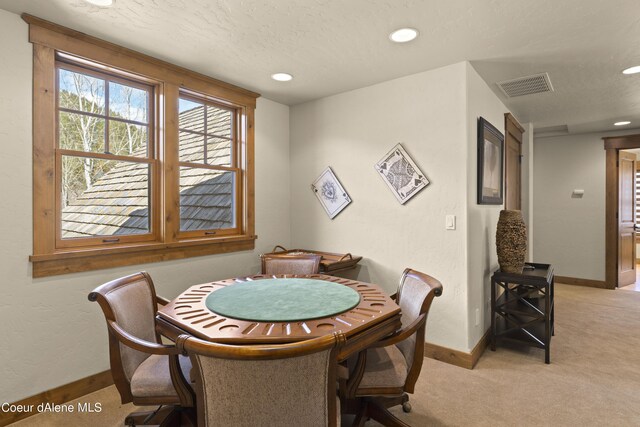 dining room featuring light colored carpet, recessed lighting, baseboards, a textured ceiling, and visible vents