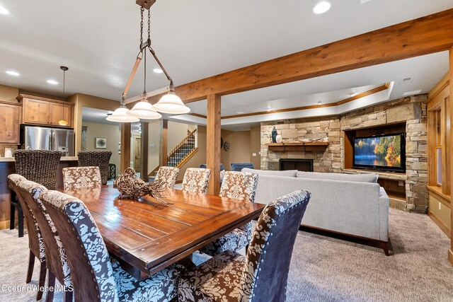 dining space with stairway, light colored carpet, recessed lighting, beam ceiling, and a stone fireplace