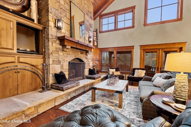living area with lofted ceiling with beams, a fireplace, wood finished floors, french doors, and wood ceiling