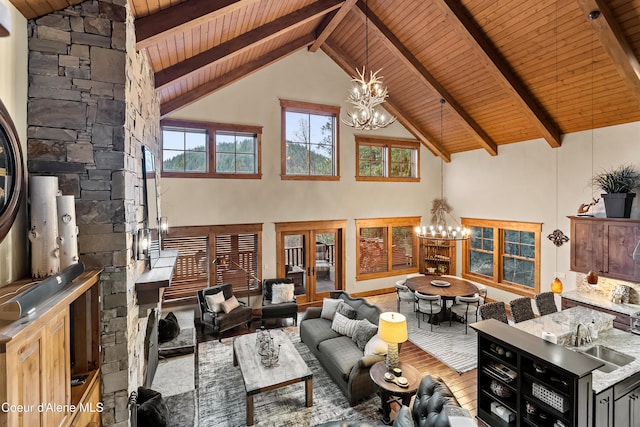 living room with beamed ceiling, high vaulted ceiling, wood finished floors, and an inviting chandelier
