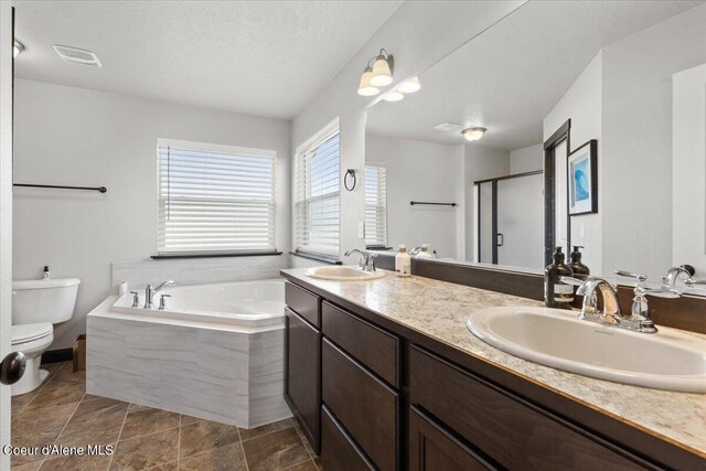 full bathroom with vanity, toilet, a textured ceiling, and shower with separate bathtub