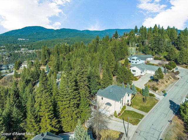 drone / aerial view featuring a wooded view and a mountain view