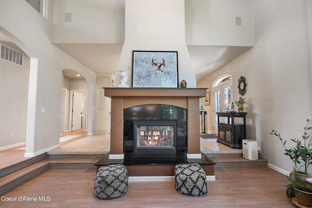 room details with baseboards, visible vents, wood finished floors, and arched walkways