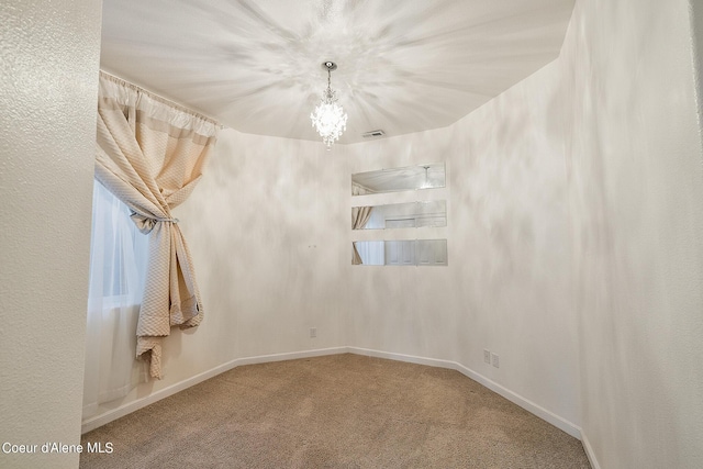 carpeted empty room with baseboards, a notable chandelier, and visible vents