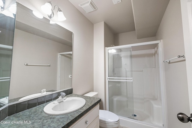 bathroom with a shower stall, visible vents, toilet, and vanity