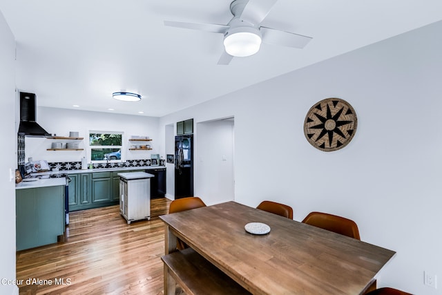 dining room with light hardwood / wood-style floors, ceiling fan, and sink