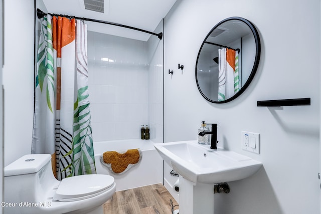 full bathroom featuring shower / bath combination with curtain, sink, hardwood / wood-style floors, and toilet