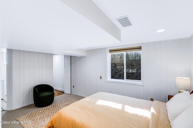 bedroom with carpet and wood walls