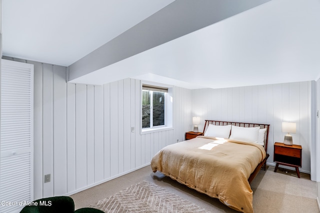 carpeted bedroom featuring wooden walls