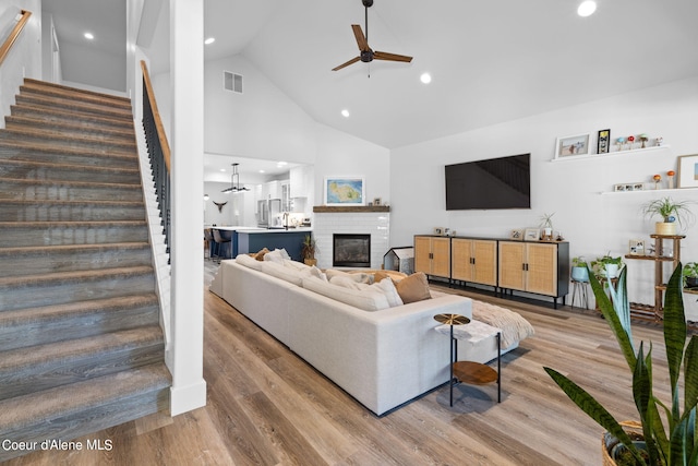 living room with high vaulted ceiling, hardwood / wood-style flooring, and ceiling fan