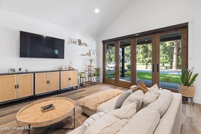 living room featuring french doors, high vaulted ceiling, and wood-type flooring