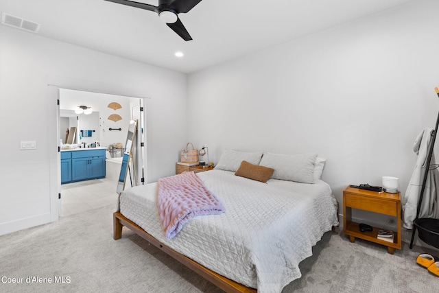 bedroom with light carpet, connected bathroom, and ceiling fan