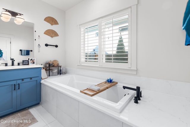 bathroom featuring vanity, tile patterned flooring, and tiled bath