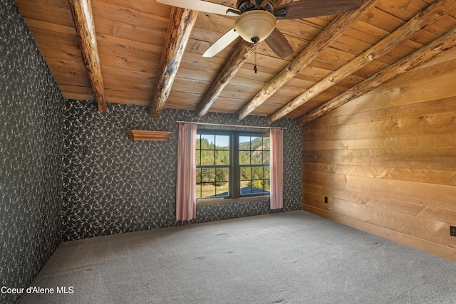 carpeted empty room featuring wooden walls, ceiling fan, wood ceiling, and vaulted ceiling with skylight