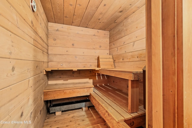 view of sauna / steam room with wood ceiling, hardwood / wood-style flooring, and wooden walls