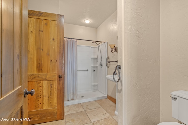 bathroom featuring walk in shower and toilet